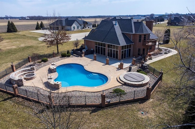 view of pool with a sunroom, a patio area, a fenced backyard, and an outdoor fire pit