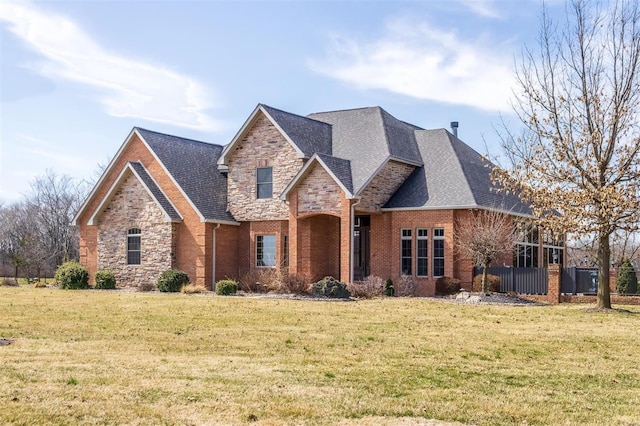 view of front of home featuring stone siding, brick siding, roof with shingles, and a front lawn