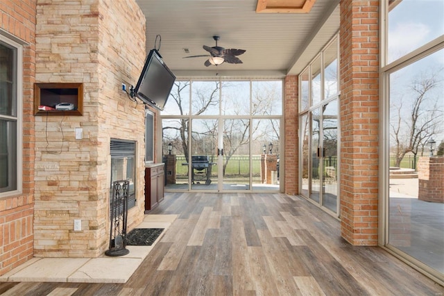 unfurnished sunroom with plenty of natural light and ceiling fan