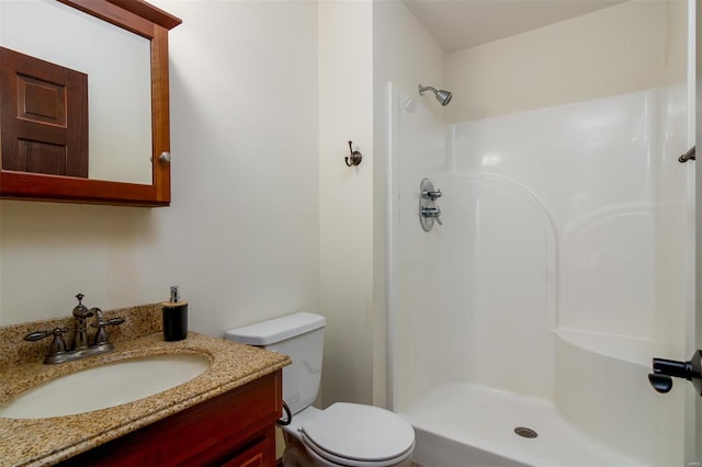 full bathroom with vanity, toilet, and a shower stall