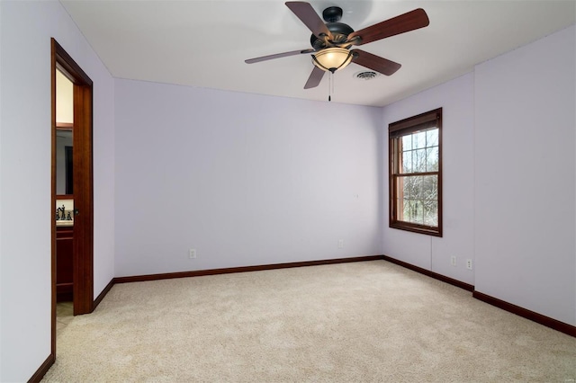 carpeted empty room featuring visible vents, baseboards, and ceiling fan