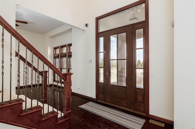 entrance foyer featuring visible vents, baseboards, stairs, wood finished floors, and a ceiling fan