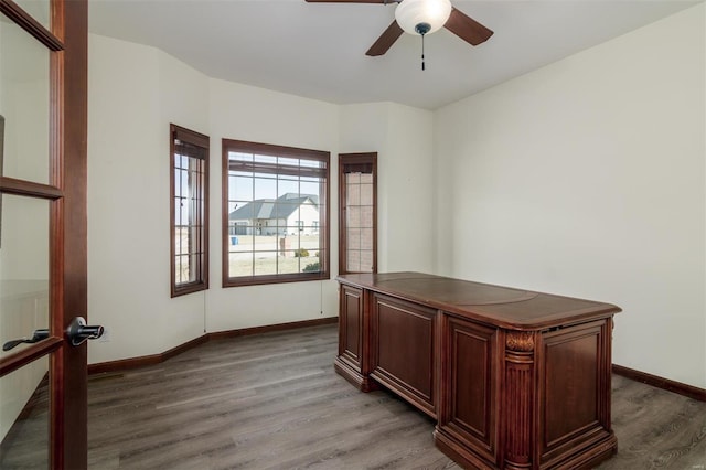 unfurnished office featuring baseboards, ceiling fan, and wood finished floors