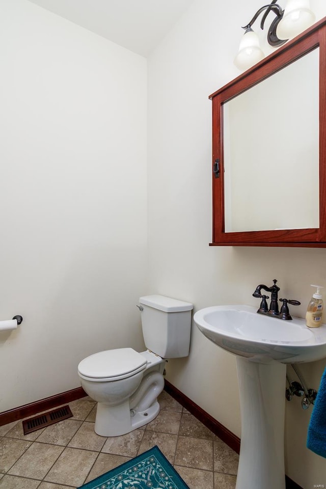 bathroom with tile patterned flooring, visible vents, toilet, and baseboards