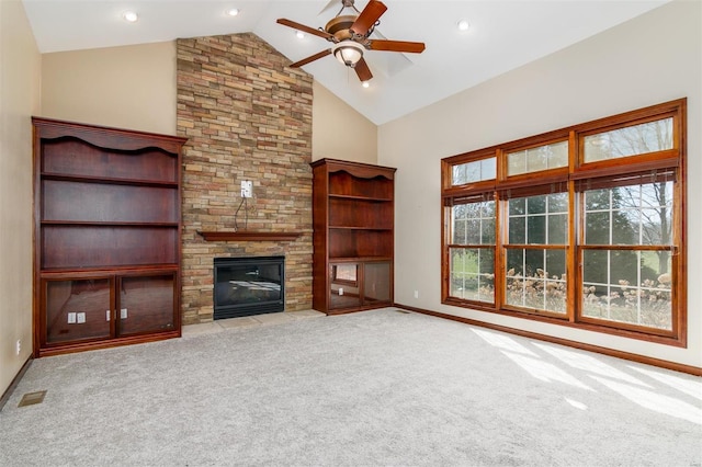 unfurnished living room with visible vents, high vaulted ceiling, carpet floors, a stone fireplace, and ceiling fan