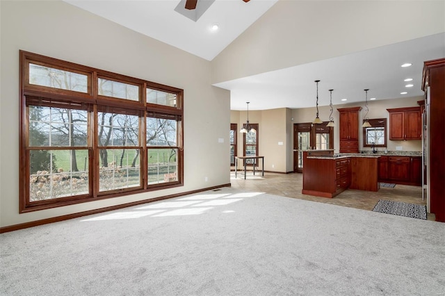 unfurnished living room featuring baseboards, high vaulted ceiling, recessed lighting, ceiling fan, and light carpet