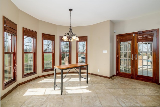 interior space with baseboards, plenty of natural light, a chandelier, and light tile patterned flooring