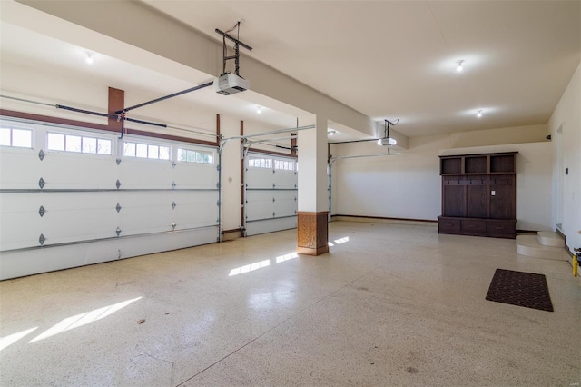 garage with a garage door opener and baseboards