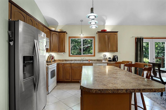 kitchen featuring hanging light fixtures, sink, a kitchen island, appliances with stainless steel finishes, and vaulted ceiling