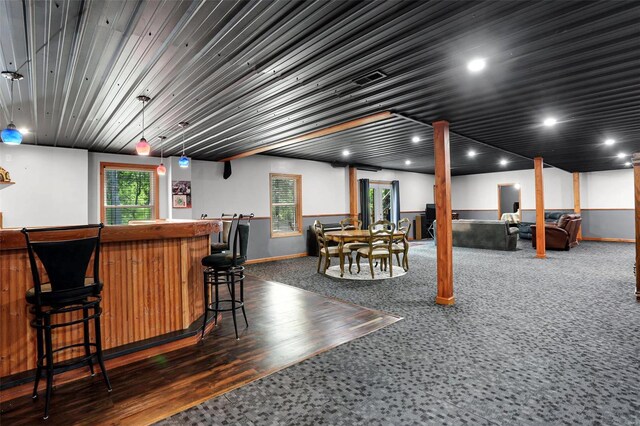 bar with decorative light fixtures and dark hardwood / wood-style flooring