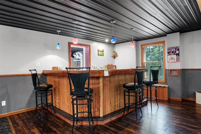 bar with hanging light fixtures and dark wood-type flooring