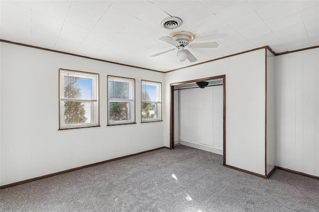 unfurnished bedroom featuring ceiling fan, visible vents, baseboards, ornamental molding, and a closet