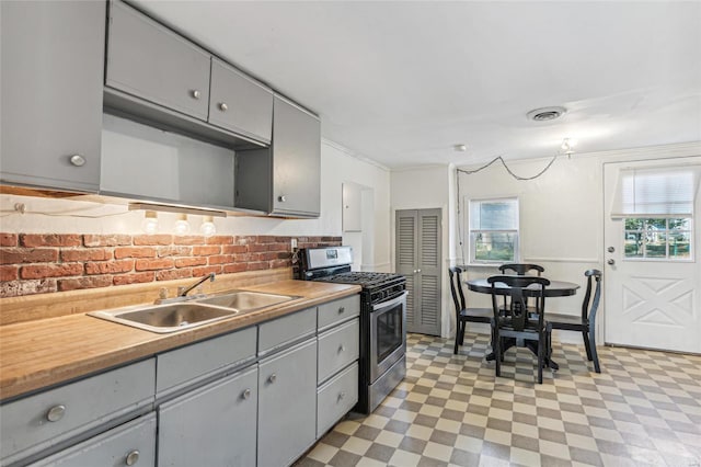 kitchen featuring a sink, gas stove, and gray cabinets