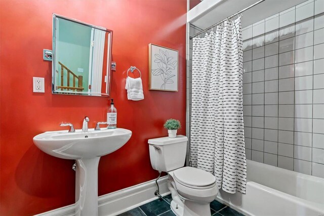 bathroom featuring shower / bath combo with shower curtain, toilet, and tile patterned floors