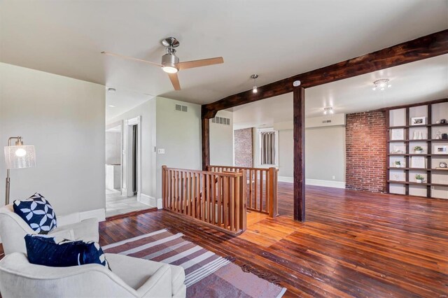 living room with wood-type flooring, beam ceiling, and ceiling fan