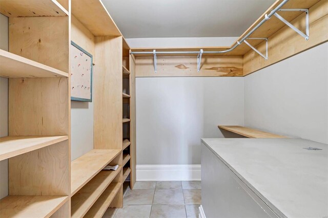 walk in closet with light tile patterned floors