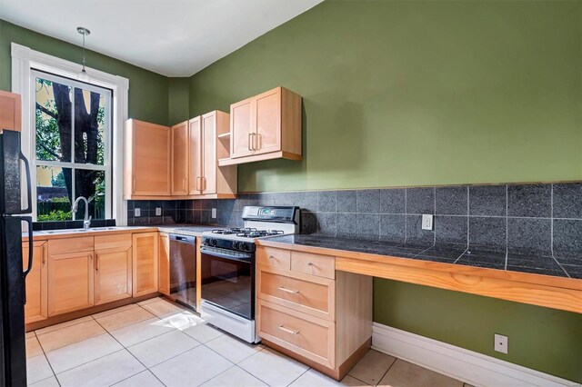 kitchen featuring white gas range oven, dishwasher, sink, hanging light fixtures, and black fridge