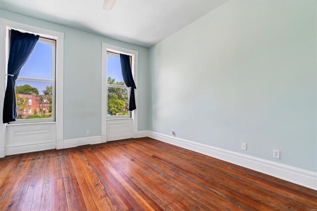 spare room with dark hardwood / wood-style flooring and a healthy amount of sunlight