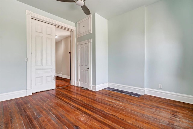 empty room with ceiling fan and dark hardwood / wood-style flooring