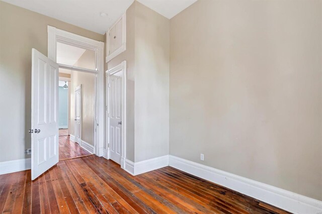 unfurnished bedroom with dark wood-type flooring