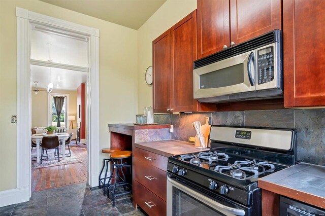 kitchen with tile counters, black appliances, dark wood-type flooring, and tasteful backsplash