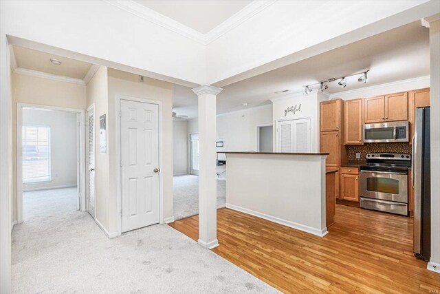 kitchen featuring tasteful backsplash, light carpet, crown molding, stainless steel appliances, and track lighting