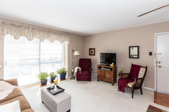 living room with a baseboard heating unit and light colored carpet