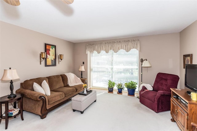 carpeted living room with ceiling fan