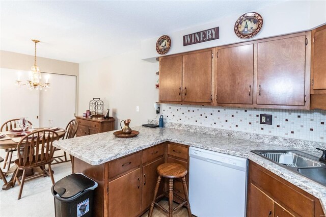 kitchen featuring backsplash, an inviting chandelier, white dishwasher, kitchen peninsula, and pendant lighting