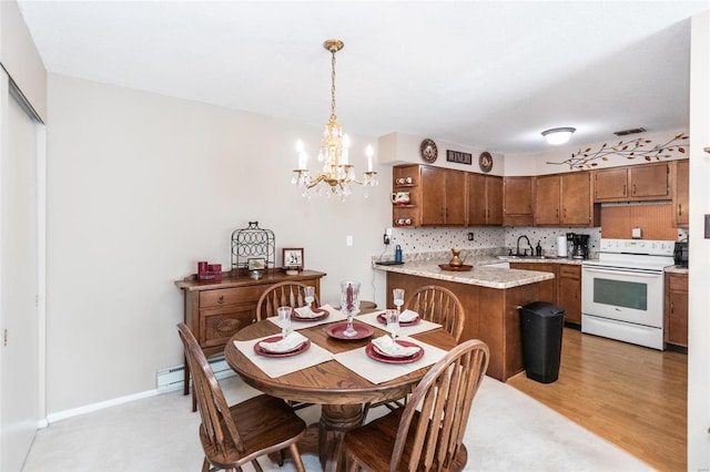 dining area with sink, light wood-type flooring, and an inviting chandelier