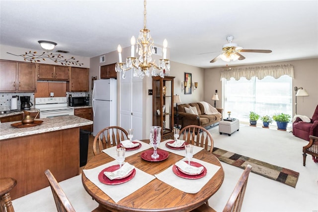 dining space with ceiling fan with notable chandelier