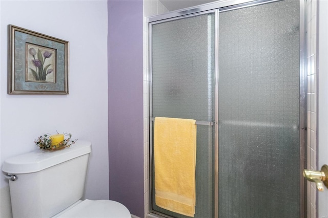 bathroom with a shower with door and toilet