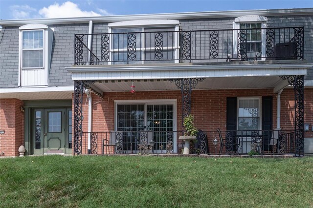 exterior space with a balcony, covered porch, and a yard