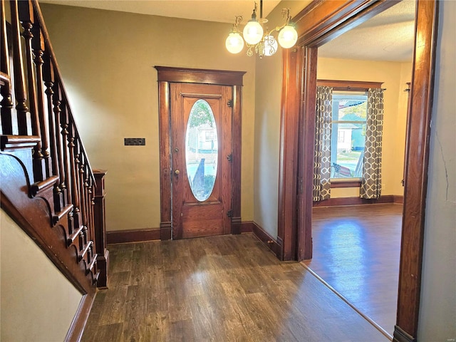 entryway with a chandelier and dark hardwood / wood-style flooring