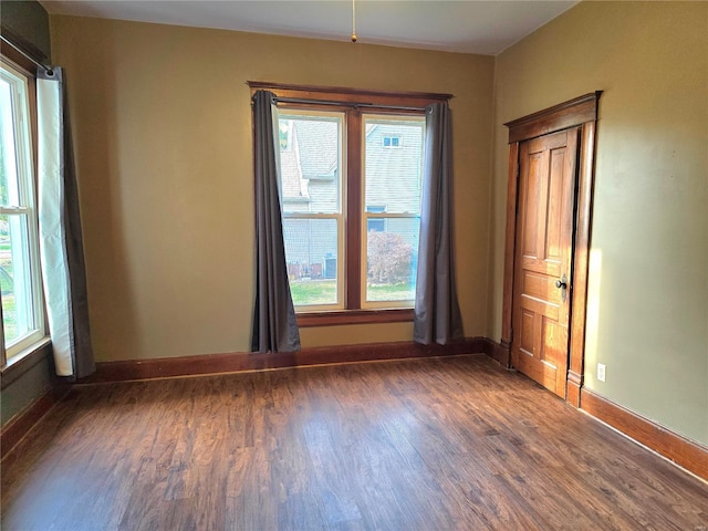 unfurnished room with dark hardwood / wood-style floors and a wealth of natural light