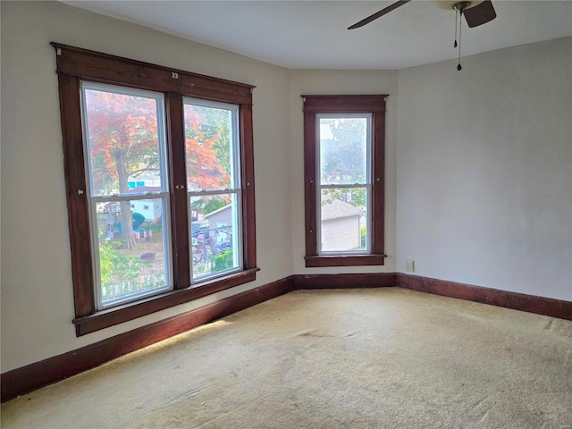 carpeted spare room featuring ceiling fan