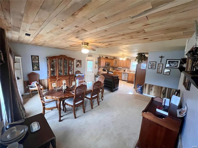 carpeted dining space featuring wood ceiling, ceiling fan, and a healthy amount of sunlight