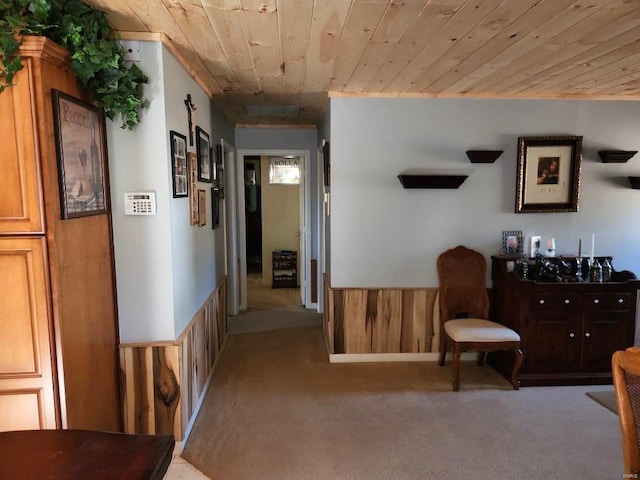 sitting room featuring light colored carpet, wood ceiling, and wood walls