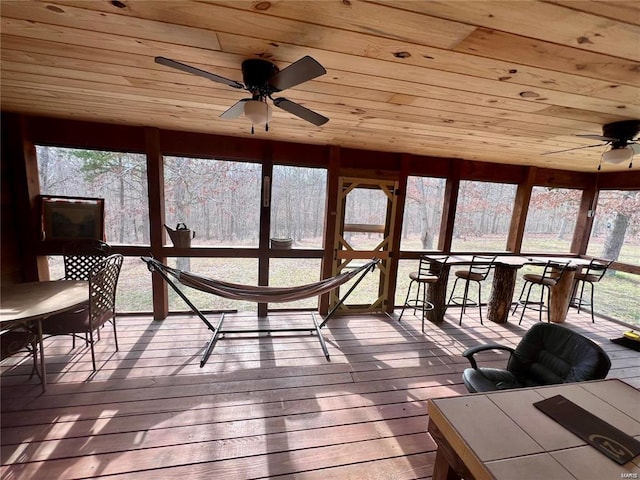 sunroom featuring wood ceiling and ceiling fan