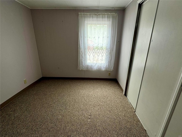 carpeted spare room featuring baseboards