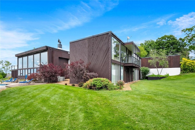 view of property exterior featuring a yard and a balcony