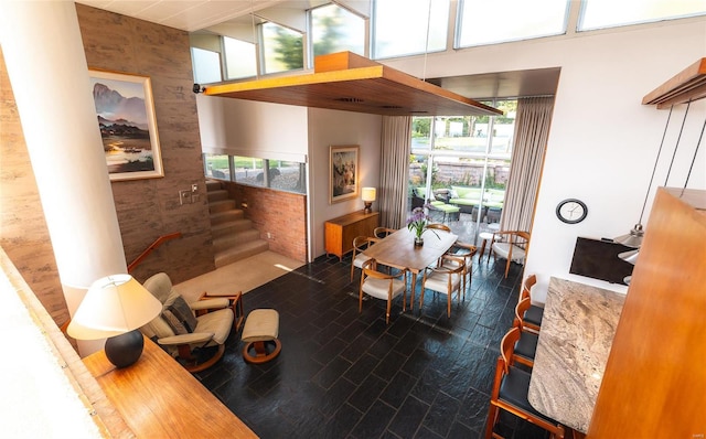 dining area featuring a healthy amount of sunlight and a towering ceiling