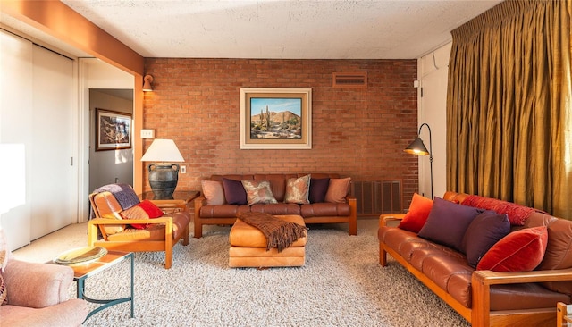 carpeted living room featuring a textured ceiling and brick wall