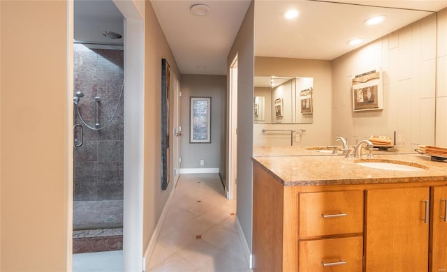 full bath with recessed lighting, tiled shower, vanity, and baseboards