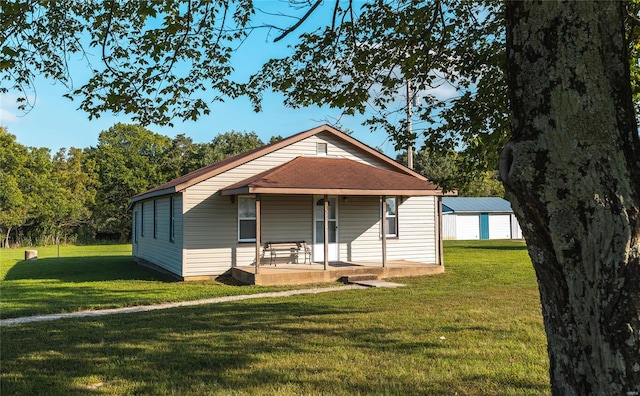 view of front of home featuring a garage, an outbuilding, and a front lawn