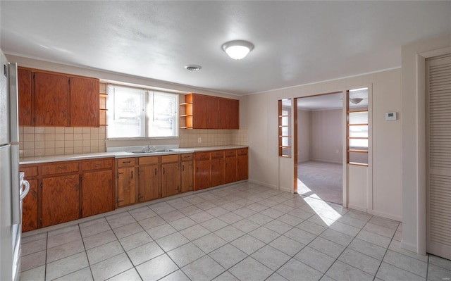 kitchen featuring decorative backsplash, sink, and light tile patterned floors