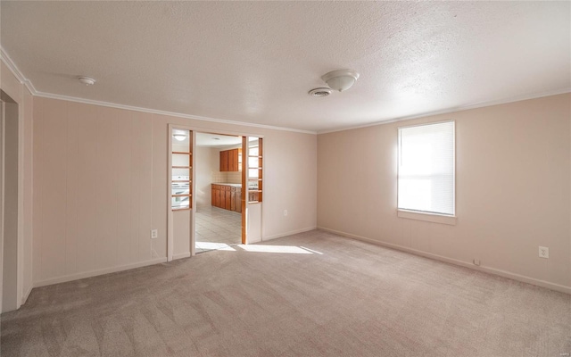 carpeted spare room featuring crown molding and a textured ceiling