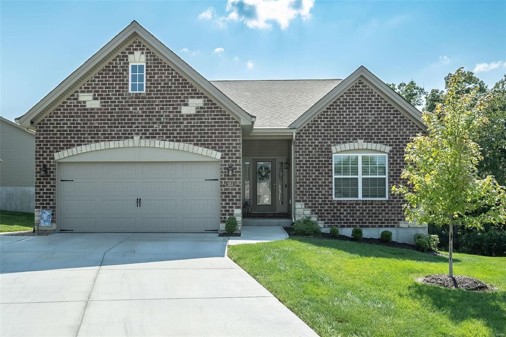 view of front of property with a garage and a front lawn