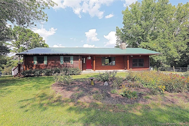 log-style house with metal roof, a chimney, a front lawn, and log siding