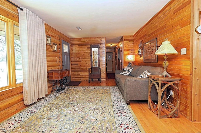 living area with wood-type flooring and log walls